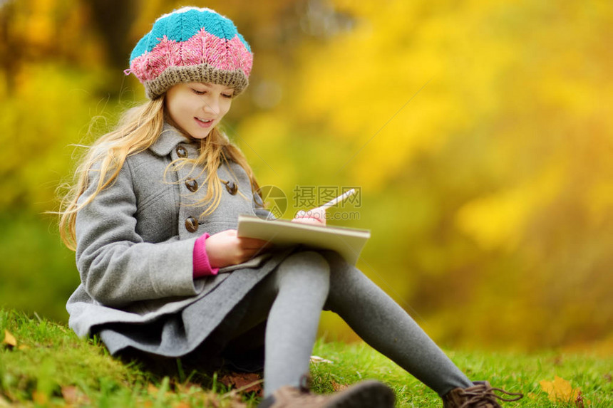 可爱的小女孩在美丽的秋日外面素描快乐的孩子在秋天的公园里玩耍孩子用彩色铅笔画图片
