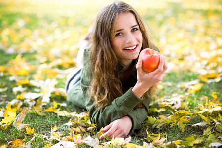 秋天在户外吃苹果的女人图片