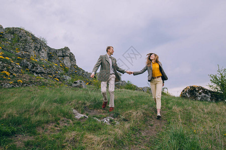春日在山上奔跑的快乐年轻夫妇图片