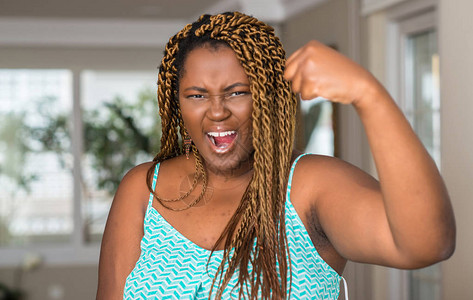 在家中愤怒和疯狂的非洲裔美国妇女举起拳头沮丧和愤怒图片