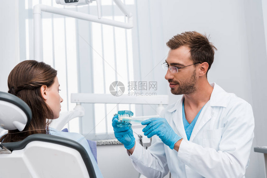 牙医在乳胶手套中有选择地重点使用牙贴近牙齿模型和有吸引力图片
