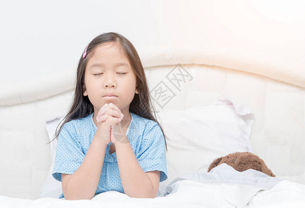 小女孩在床上祈祷图片