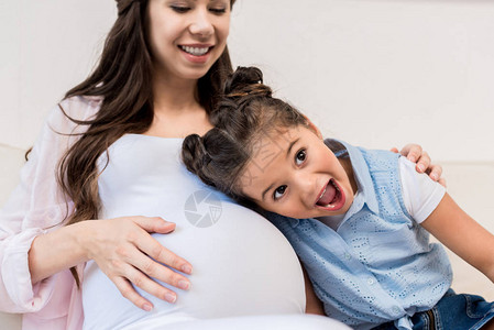 小女孩听她怀孕母亲肚子里的肚子满图片
