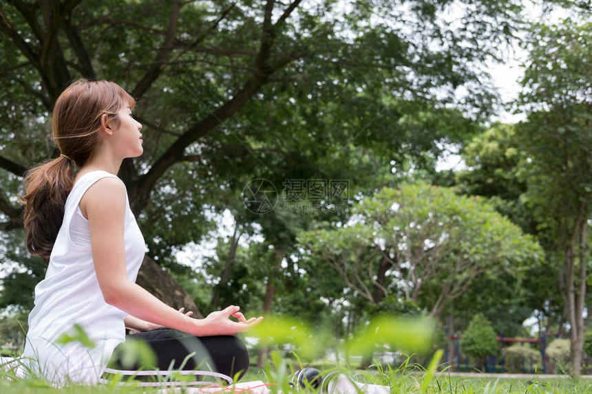 夏季在公园户外瑜伽亚洲健身女人坐在莲花位置有禅宗手势的年轻女健康的生活方图片