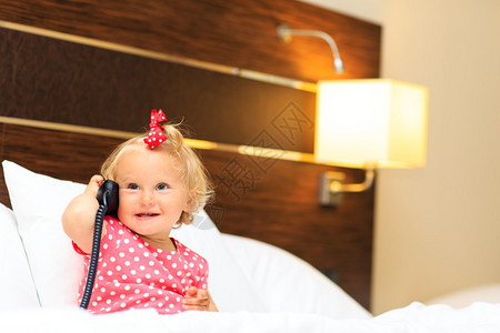 可爱的小女孩在酒店房间打电话图片