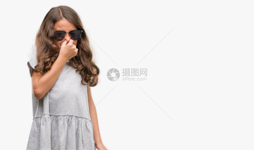 戴着墨镜的黑发西班牙裔女孩闻到某种臭味和恶心难以忍受的气味图片
