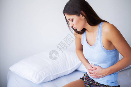胃痛不健康的年轻女人肚子疼躺图片