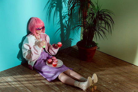 穿着粉红假发的笑脸女孩在坐地板上吃蛋图片