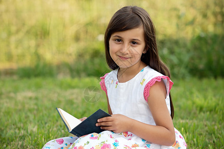 小女孩在草地上看书图片