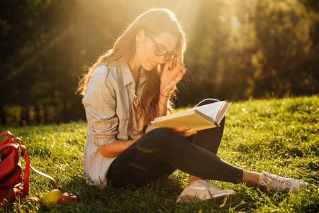 坐在公园草地上看书的眼镜中美图片