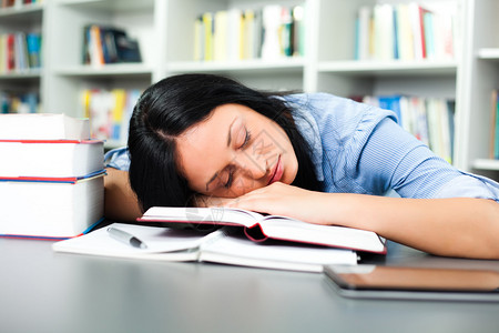 疲倦的学生睡在图书馆图片