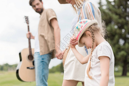 父母看着可爱的小女儿在公园中图片