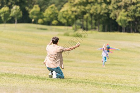 看着女儿在公园里玩风筝的游戏图片
