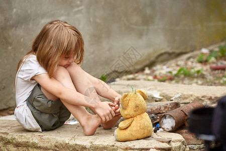 在街上玩用过的泰迪熊贫穷和贫穷的姿势失去童年社会不平等图片