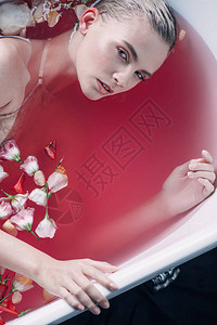 浴缸里有粉红水和花瓣的感女人仰望着黑图片