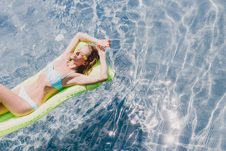 湿润的金发感女人在游泳池绿泳图片