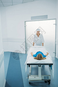 带着微笑的医生在走廊上用医疗担架图片