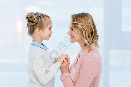 母亲和女儿在家中手牵背景图片