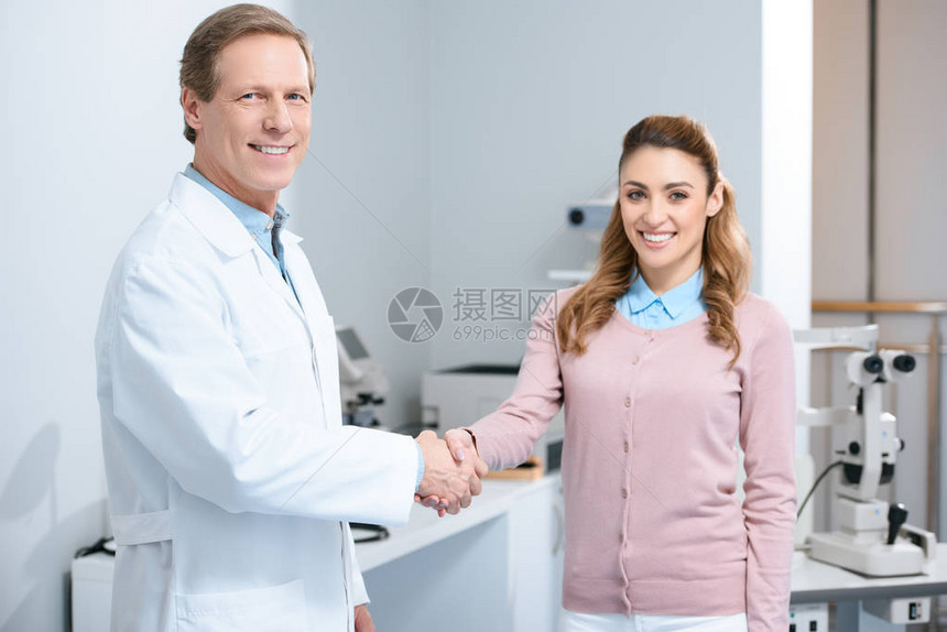 眼科医生和病人在诊所握手时微图片