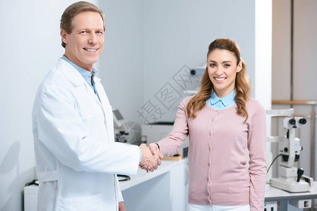 眼科医生和病人在诊所握手时微图片