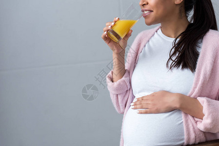 喝橙汁的美籍女孕妇的图片