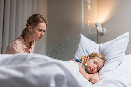 正在医院睡觉的生病孩子的母亲在图片
