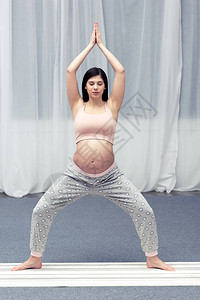 年轻孕妇在家练习瑜伽图片