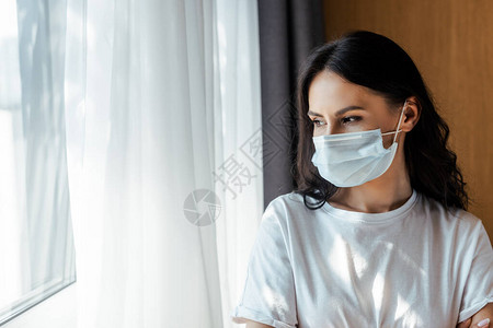 身戴医疗面具透过窗户看自我孤立的有吸引图片