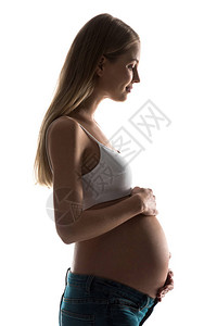 孕妇触摸她的肚子被白色隔离的剪影图片