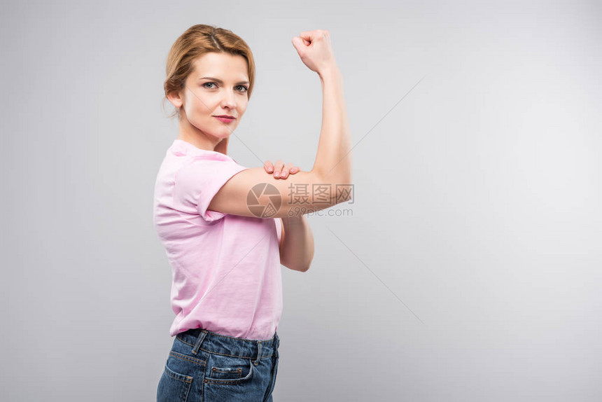 身穿粉色T恤展示肌肉的女权主义女图片