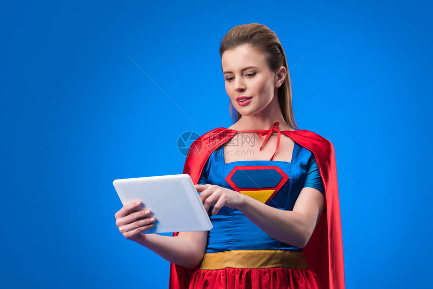 穿着超级英雄服装的caucasian女人肖像用蓝色孤图片