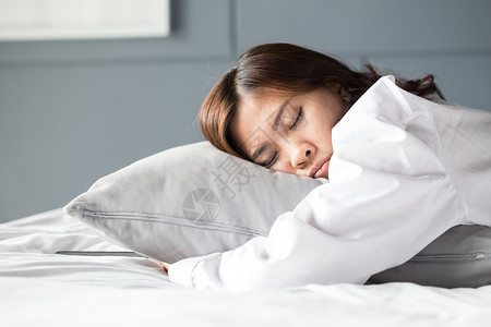 睡觉在床上的亚裔妇女图片