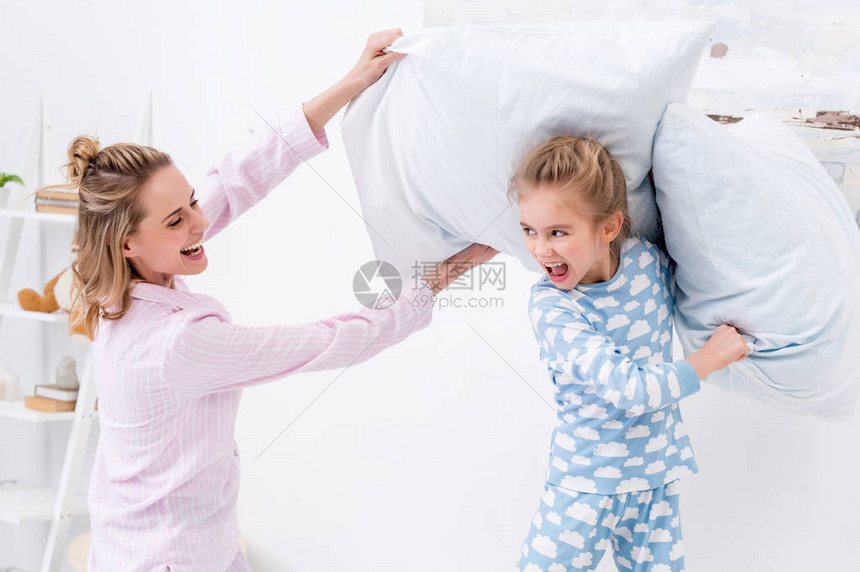 母亲和女儿在家中与枕头争吵图片