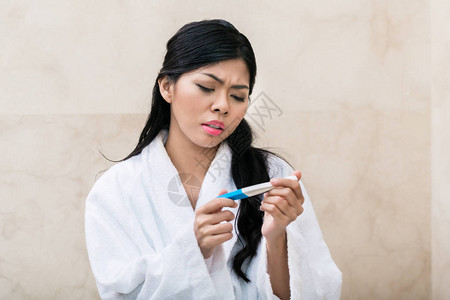 早上检查怀孕测试的亚裔图片