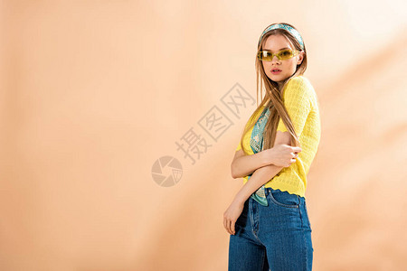 穿着牛仔裤黄色T恤衫太阳眼镜和丝围图片