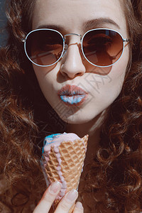 戴墨镜吃冰淇淋的红发女孩特写肖图片