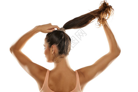 年轻女子用白色背景的马尾辫将头发图片