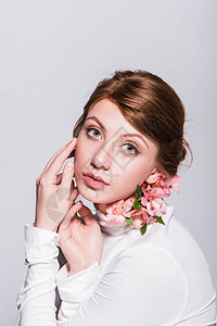 美丽的感年轻女人的肖像用百合花朵看着灰图片