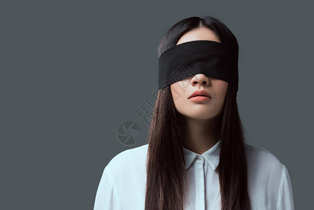 身戴黑色蒙黑眼罩的年轻妇女在图片