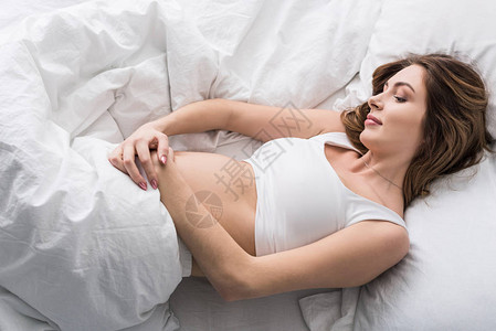 漂亮的孕妇躺在床上摸肚子图片