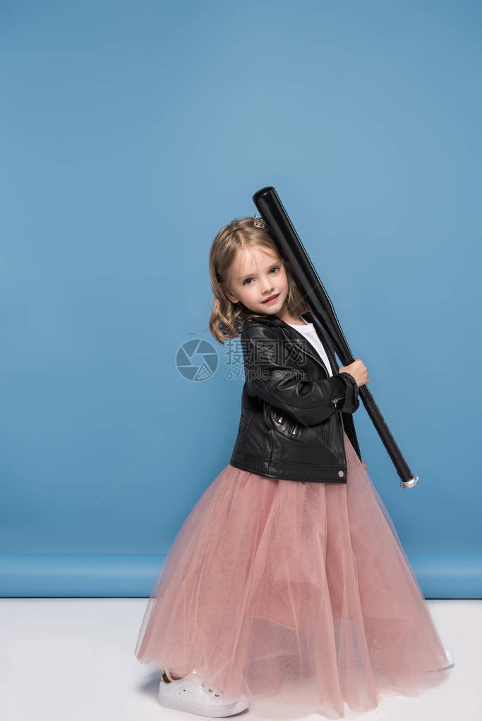 穿着皮夹克和粉红色裙子的可爱小女孩拿着棒球棍图片