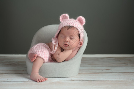 一个两周前刚出生的女婴睡在一张小椅子上图片