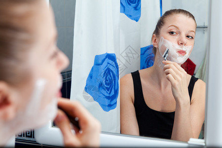 有趣的女孩在浴室刮脸图片