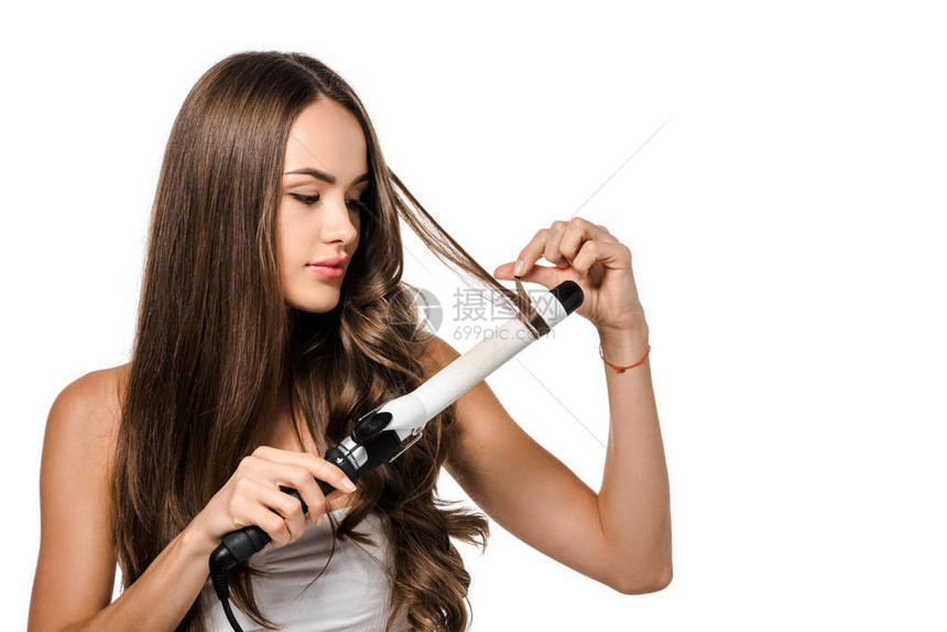 长棕色头发的漂亮女孩用卷曲铁图片