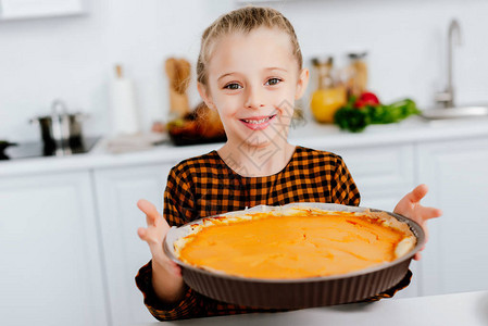 快乐的小孩拿着烤盘和感恩节派图片
