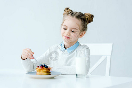 可爱孩子的肖像画牛奶和自制煎饼还有蜂蜜和图片