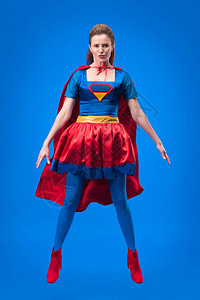 穿着服装的美丽超级女超人在蓝色图片