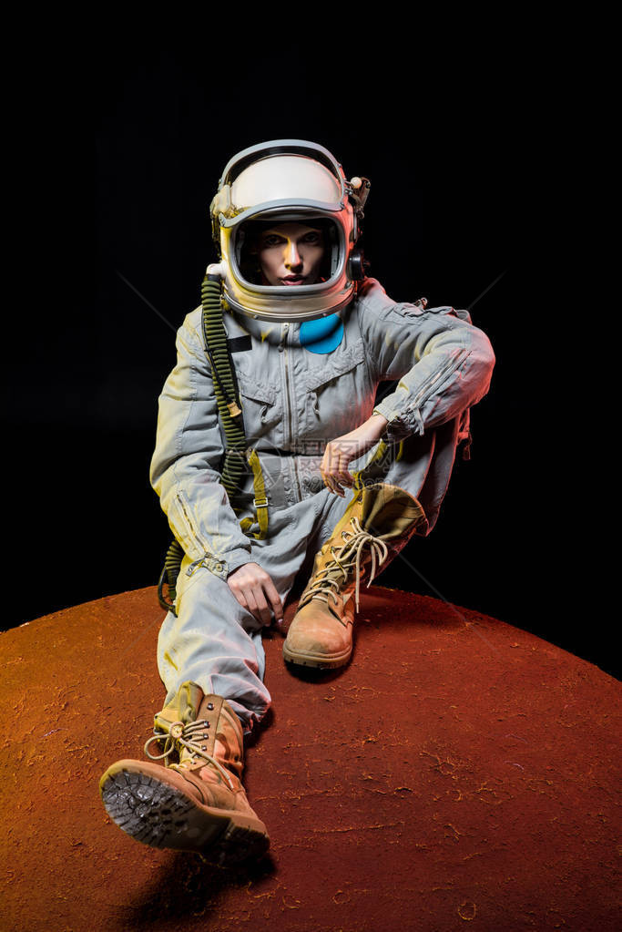 年轻宇航员身穿太空服头盔坐图片