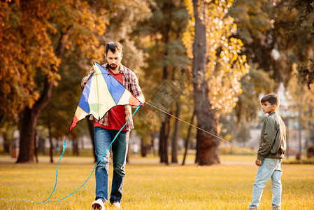 父子在秋季公园玩风筝图片