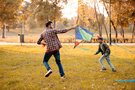 秋天公园里玩风筝的父子图片